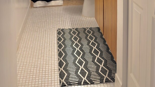 A bathroom with a toilet, a sink, a shower curtain, and a patterned rug. - Cozy 1-bedroom apartment in adorable Lauderhill with AC (Lauderhill)