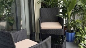 Un balcone con mobili in vimini e piante in vaso.