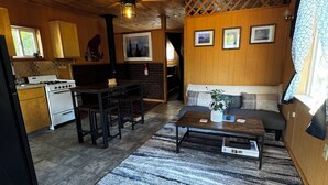 Acogedor interior de cabaña con cocina, comedor y sala de estar.