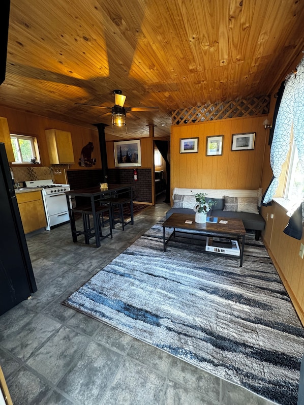 A cozy cabin interior with a kitchen, dining area, and living room.