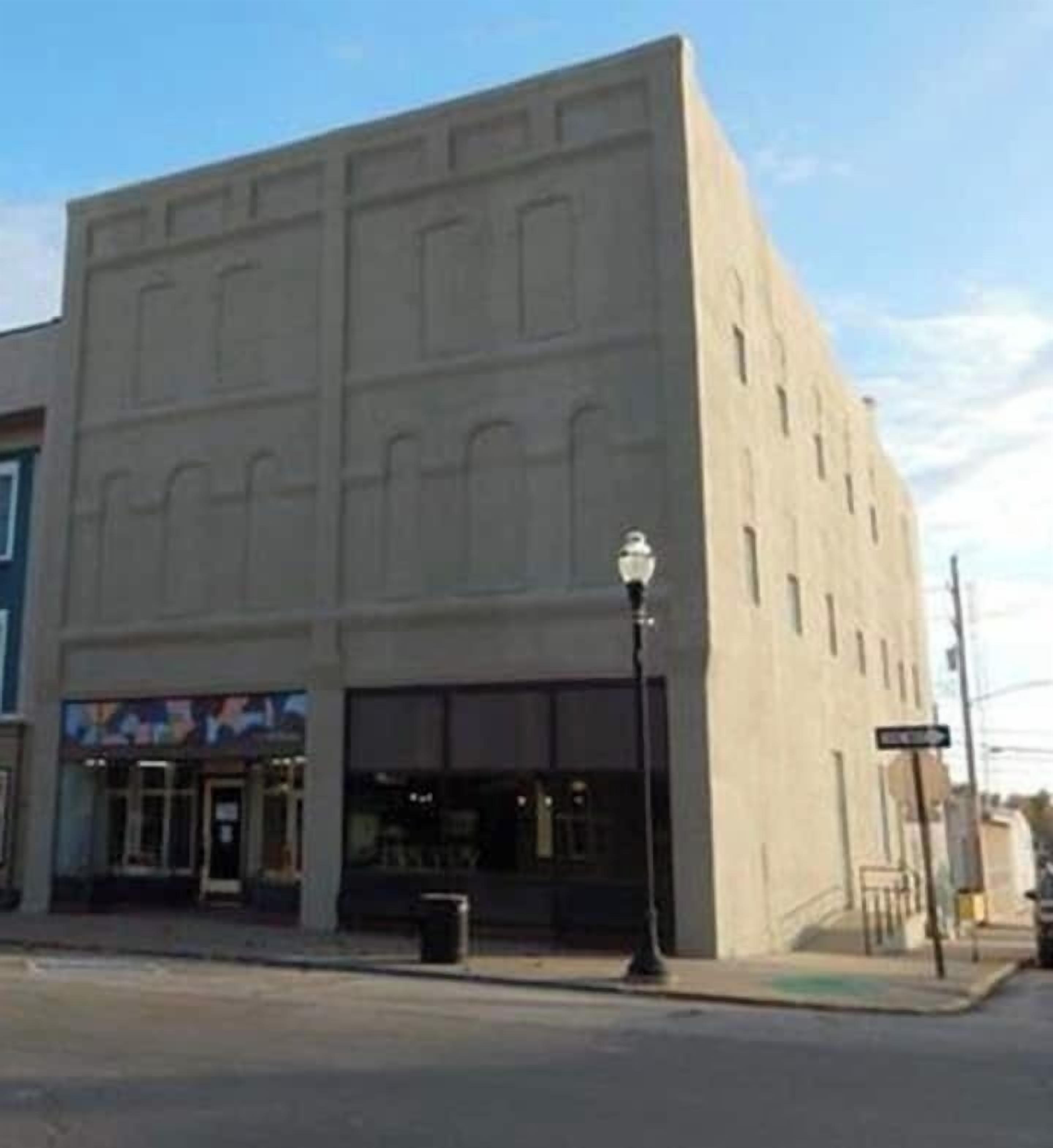 A building with a flat facade, large windows, and a street lamp.