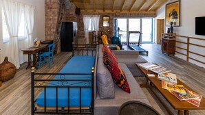 A cozy room with a bed, a sofa, a table with magazines, a TV, and a window with curtains. - Villa with pool and sea view (Pasman)