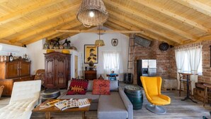 A rustic interior with a high wooden ceiling, a sofa, a yellow chair, and a dining area. - Villa with pool and sea view (Pasman)