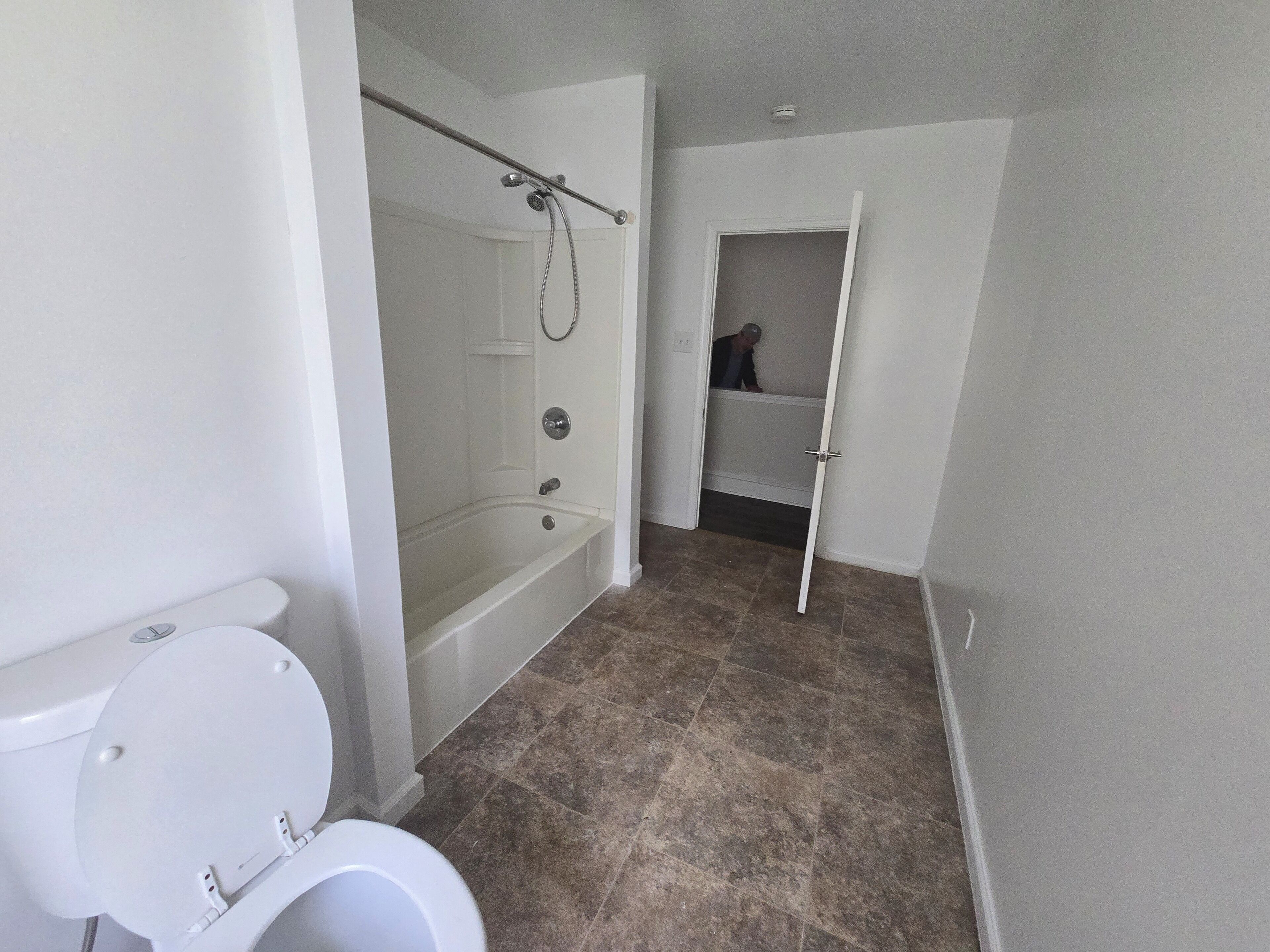 A bathroom with a toilet, a bathtub, and a shower.