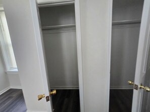 A closed door with a brass handle, a window with blinds, and a dark floor.