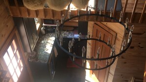 A rustic interior with a chandelier, wooden beams, and a view of the outside. - Cozy cabin in pleasant Little River perfect 4 a relaxing getaway.6 min 2beach.  (Little River)