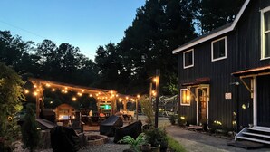 An outdoor seating area with string lights, covered furniture, and potted plants. - Cozy cabin in pleasant Little River perfect 4 a relaxing getaway.6 min 2beach.  (Little River)