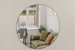 A room with a window, a sofa, and a small table with a vase. - New 4BR Home, Bedworth, Driveway Parking, Workspace, WiFi, Near M6 (Bedworth)