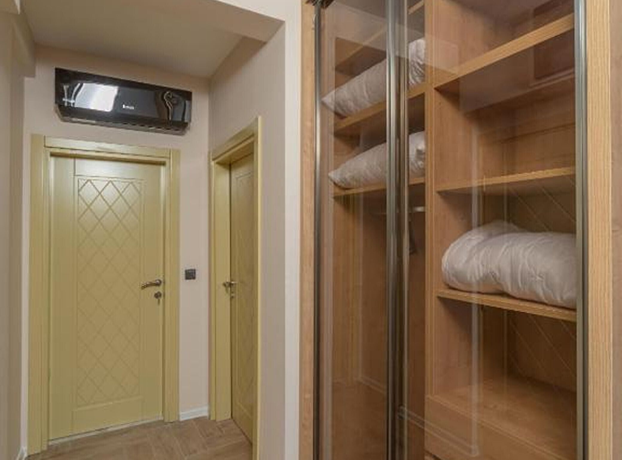A room with a wardrobe, a door, and a bed.