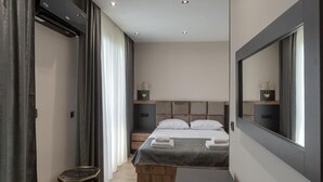Una camera da letto moderna con un letto, comodini, uno specchio e un tavolino.