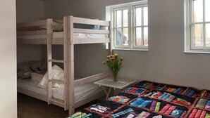 A bunk bed room with a window and a small table with flowers. - 4 Star Holiday Home in Rudkobing (Rudkobing)