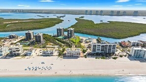 Ein Küstenort mit Strandhotels, einem Sandstrand und einer Marina.