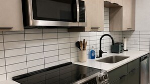 Una cocina con microondas, estufa, fregadero y lavavajillas.
