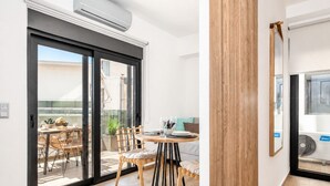 Een modern interieur met een eethoek, een schuifdeur naar buiten en een zichtbare airconditioning.
