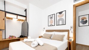 Een moderne slaapkamer met een bed, nachtkastjes, een kledingkast en kunst aan de wanden.