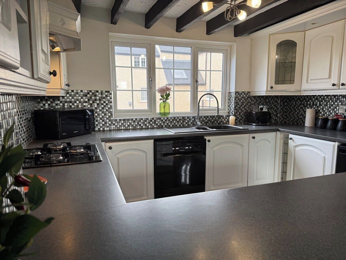 A kitchen with white cabinets, a black stove, and a dishwasher.