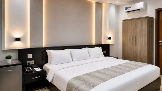 Une chambre moderne comprenant un lit, des tables de chevet, un bureau, un climatiseur et une armoire.