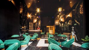 A restaurant with green chairs, marble walls, and a statue. - Aman Luxury 23 Bedroom 3 Pool (Medellín)