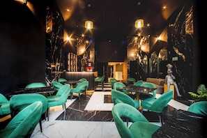 A restaurant with green chairs, marble walls, and a statue. - Aman Luxury 23 Bedroom 3 Pool (Medellín)
