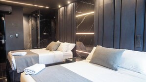 A modern hotel room with two beds, a large mirror, and a marble wall. - Aman Luxury 23 Bedroom 3 Pool (Medellín)