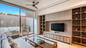 Una sala de estar moderna con sofá, mesa de centro, televisor y estanterías empotradas.