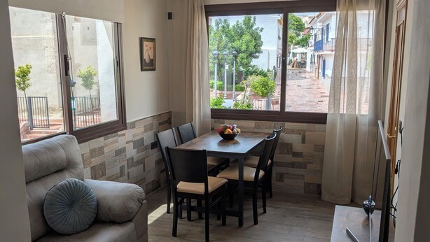 Un soggiorno moderno con zona pranzo, un divano, un tavolino e una TV.