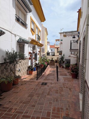 A narrow alley with potted plants and a brick pathway. - Luminous Duplex centrally located in Arroyo de la Miel, 3 minutes from downtown. (Benalmádena)