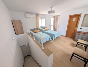 A bedroom with two beds, a ceiling fan, a wooden dresser, a desk, and a chair. - Luminous Duplex centrally located in Arroyo de la Miel, 3 minutes from downtown. (Benalmádena)