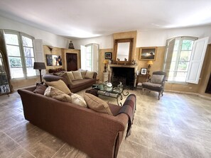 Ein Wohnzimmer mit braunem Sofa, Kamin und großem Spiegel.