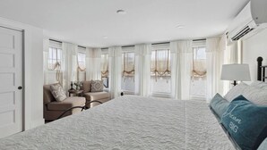 A hotel room with a large bed, a sofa, a desk, and a window with curtains. - Luxury Lakehouse on the water! (Tully)