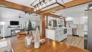 A modern kitchen with white cabinets, a wooden island, and a built-in oven. - Luxury Lakehouse on the water! (Tully)