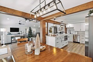 Eine moderne Küche mit weißen Schränken, einer Holztreseninsel und einem eingebauten Backofen.