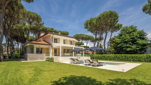 A two-story house with a swimming pool, outdoor seating, and a well-maintained lawn. - Villa Smeralda (Marina di Pietrasanta)