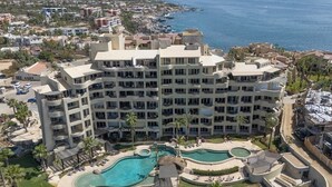 A multi-story hotel with a pool area, including a hot tub and a children's pool. - Stylish Coastal Retreat With Breathtaking Views, Resort Pool & Private Balcony (Cabo San Lucas)