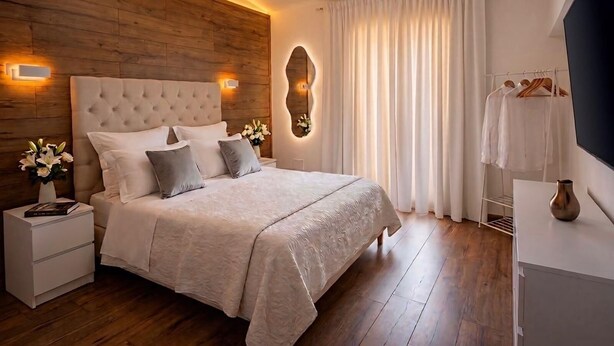 A modern bedroom with a wooden headboard, a large bed with a textured blanket, bedside tables with lamps, and a mirror. - Terme house (Bagni San Filippo)