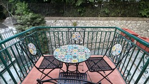 A patio with a round table and four chairs, surrounded by a green metal railing. - Terme house (Bagni San Filippo)