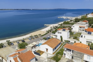Eine Küstenwohngegend mit Häusern, einem Strand und einem Yachthafen.