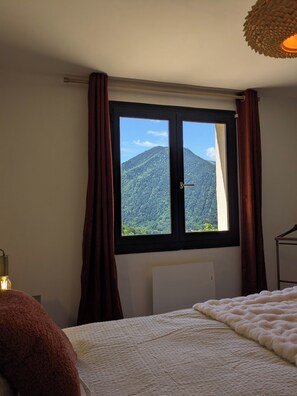 Un dormitorio con una ventana grande, una cama y un radiador.