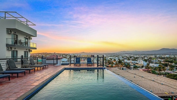 A rooftop pool with lounge chairs, a view of the cityscape, and a clear sky. - Dog-friendly Loft With Rooftop Infinity Pool, Gym, Balcony & Central AC (Cabo San Lucas)