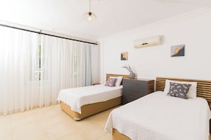 A bedroom with two beds, a window with sheer curtains, a ceiling light fixture, and a small wall-mounted air conditioner. - Tulip ,Sea-View Fabulous 4-bedroom villa in Kalkan (Antalya)