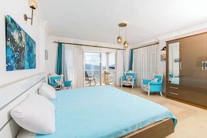 A bedroom with a bed, two chairs, a wardrobe, and a balcony with a view. - Tulip ,Sea-View Fabulous 4-bedroom villa in Kalkan (Antalya)