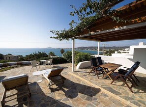 A patio with stone flooring, outdoor furniture, and a view of the sea. - Charming Naxos Villa, Ocean Views, Modern Comfort, Tranquil Escape (Naxos)