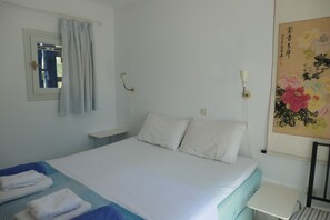A hotel room with a bed, a bedside table, a wall-mounted lamp, and a painting. - Charming Naxos Villa, Ocean Views, Modern Comfort, Tranquil Escape (Naxos)