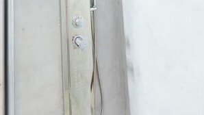 A shower with control knobs and a hose.