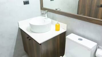 Ein Badezimmer mit Waschbecken, Spiegel und Toilette.