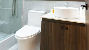 A modern bathroom with a toilet, a sink, and a shower area. - Boutique Hotel - Suite Sencilla Ramada (San Salvador)
