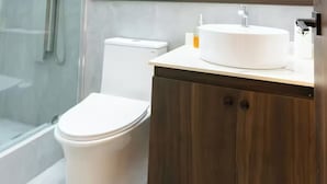 A modern bathroom with a toilet, a sink, and a shower area.