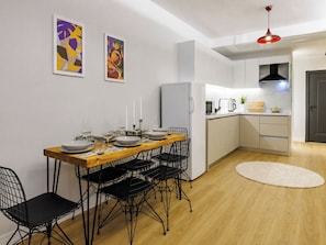A modern kitchen with white cabinets, a wooden dining table, and black wire chairs. - House Sleeps 6 With Air Conditioning (Istanbul)