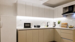 A modern kitchen with a microwave, toaster, kettle, and a small plant on the counter. - Fantastic Cihangir 3 Bedroom Apt At Monnas Suite (Istanbul)