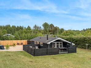 Ein modernes Haus mit Terrasse, Schornstein und Satellitenschüssel.